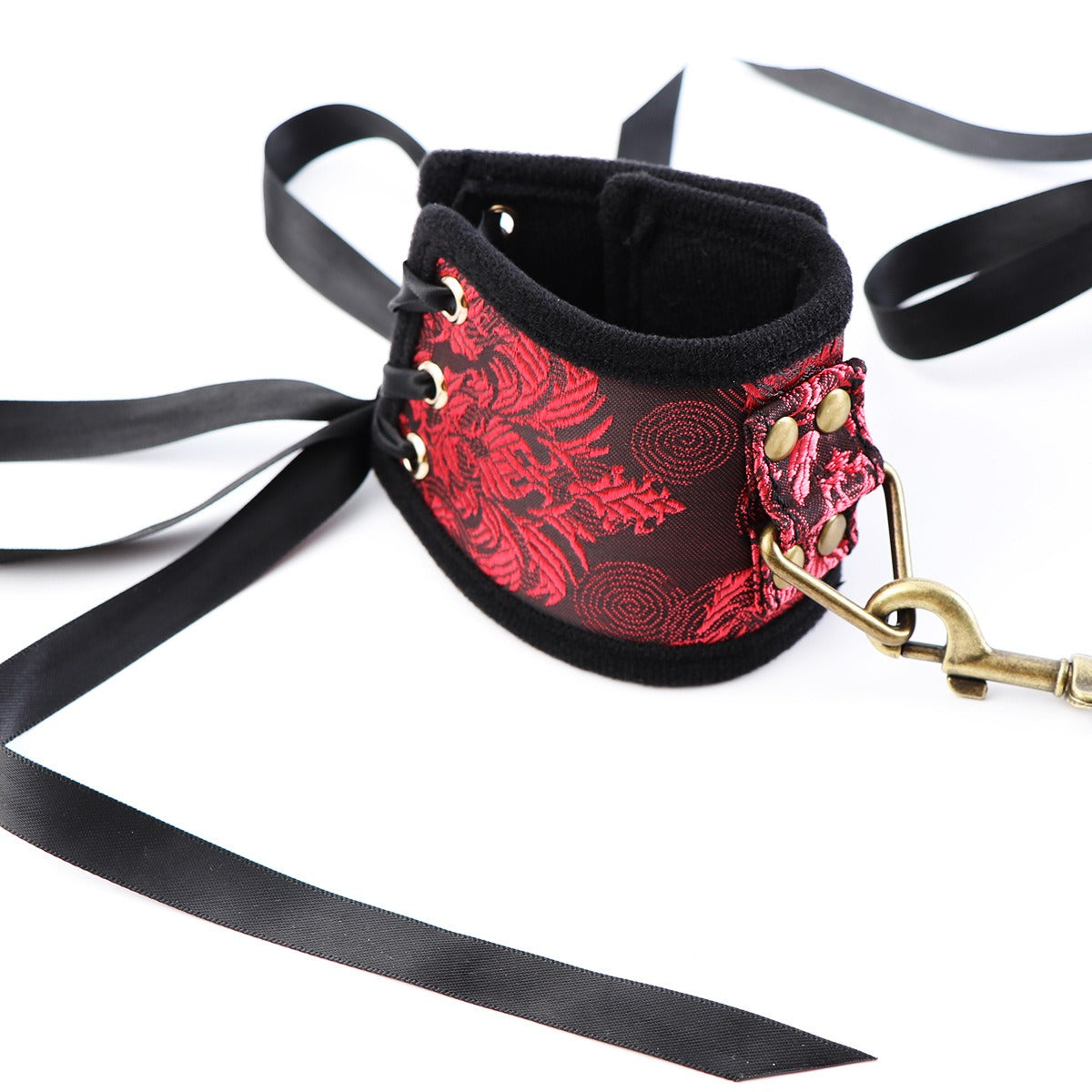 Velcro hand cuffs with red ribbon and gold accents for restraint play